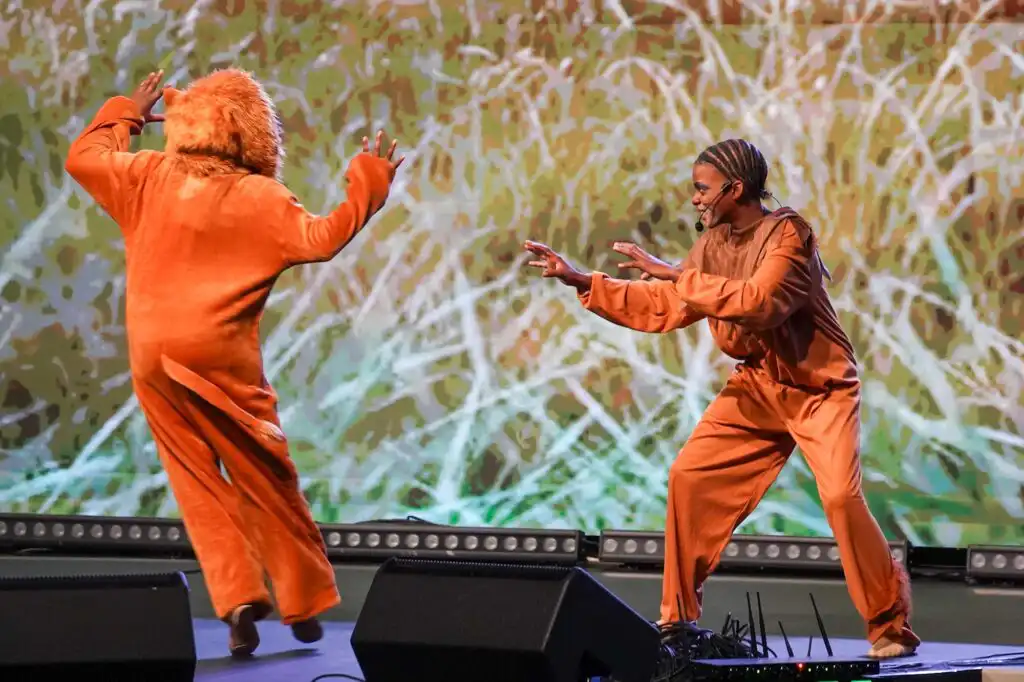 Performers in orange costumes dancing